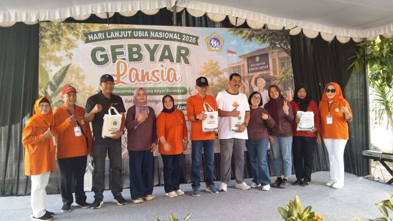 Camat Gunung Anyar Indra Fajar Swasana (tengah memakai topi) bersama perwakilan panitia dan undangan berfoto bersama di atas panggung utama saat penyerahan bantuan paket sembako secara simbolis kepada lansia saat perayaan Hari Lanjut Usia Nasional (HLUN) pagi tadi. (jatimsport.com/Keyzei Zahir)